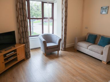 A living room with a sofa and armchair at Bungalow 15 Eamont Park in Penrith