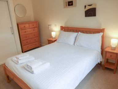 A bedroom with a bed and dresser at Bungalow 15 Eamont Park Penrith