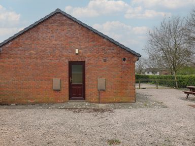 A brick wall with a door at Bungalow 15 Eamont Park Penrith