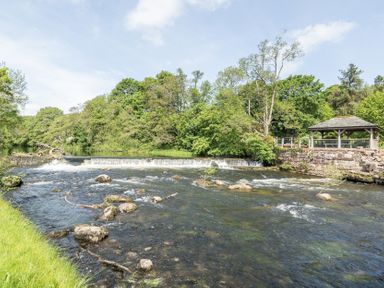 A river with a waterfall and a gazebo at Jubilee Ground-floor Double Bedroom Penrith