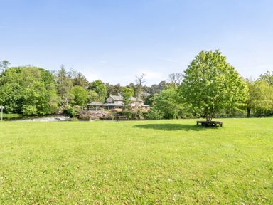 An outdoor area with a tree, grass, and a river at Jubilee Ground-floor Double Bedroom in Penrith