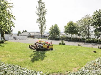 A garden with a boat planter and greenery at Number 42 Wemyss Bay