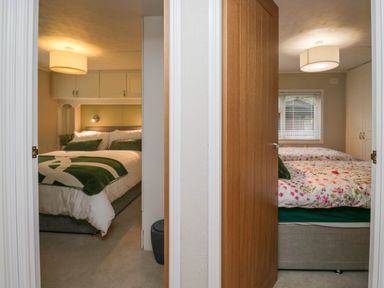 Two bedrooms each with a bed bedside lights overhead lamps and built in wardrobes at Robins Lodge in White Cross Bay near Troutbeck Bridge