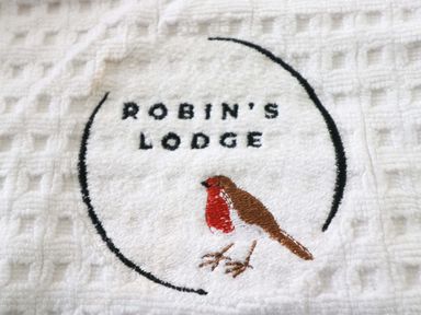 A towel with a logo featuring a robin at Robin's Lodge White Cross Bay near Troutbeck Bridge