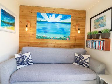 A living room with a sofa and wall art at The Studio in Feock near Truro