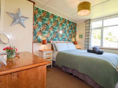 A bedroom with a bed and bedside table at The Studio in Feock near Truro