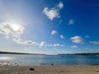 A beach with water under a clear sky at The Studio in Feock near Truro