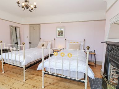A bedroom with two beds and a fireplace at 18 Pakefield Road in Lowestoft