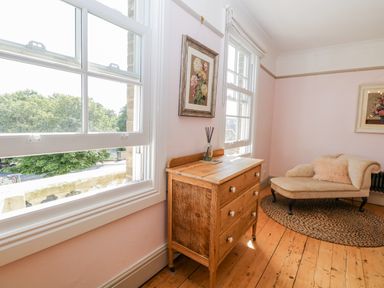 A living room with a window and wooden drawer unit at 18 Pakefield Road in Lowestoft