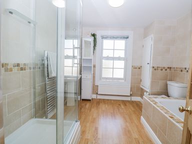 A bathroom with a shower, bathtub, and sink at 18 Pakefield Road in Lowestoft