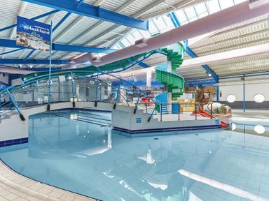 An indoor water park with a pool and water slides at Pines 15 Porthcawl