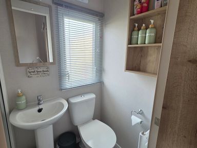 A bathroom with a sink and toilet at Pines 15 in Porthcawl