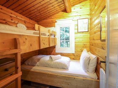 A bedroom with a bunk bed and a single bed at Y Bwthyn Pren, Cabin 209, Trawsfynydd