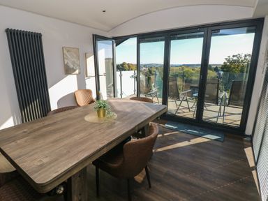 A dining room with a table and chairs at 10 Brython Place in Tenby