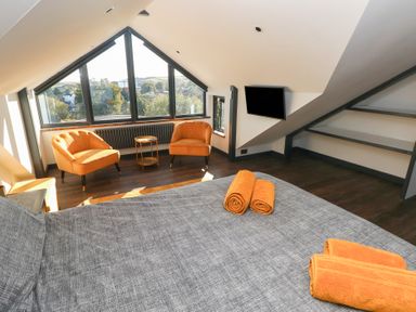 A bedroom with a bed and seating area at 10 Brython Place Tenby