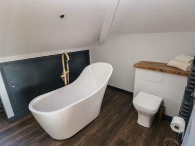 A bathroom with a bathtub and toilet at 10 Brython Place in Tenby
