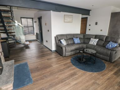 A living room with a sofa and a coffee table at 10 Brython Place Tackley