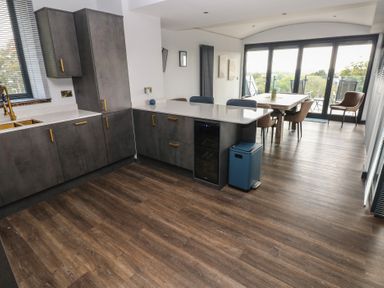 A kitchen with cabinets and dining area at 10 Brython Place Tackley