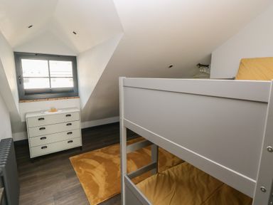 A bedroom with a bunk bed and dresser at 10 Brython Place in Tackley