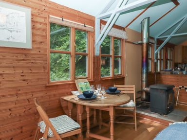 A dining area with a table and chairs at The Boat House in Ashprington