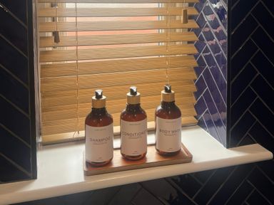 Bottles of shampoo, conditioner, and body wash on a windowsill at Craster House in Seahouses