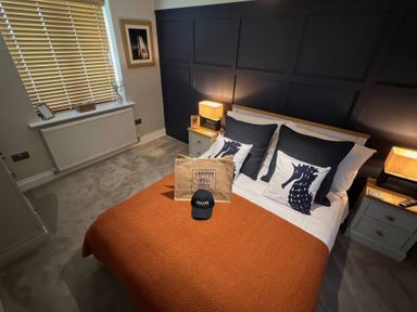A bedroom with a bed and decorative pillows at Craster House in Seahouses