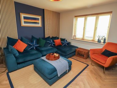 A living room with a sofa and an armchair at Craster House in Seahouses