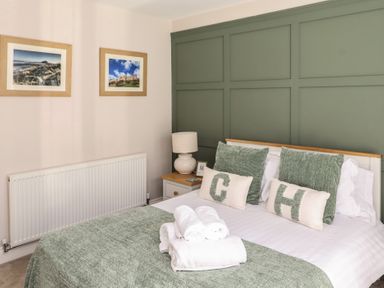 A bedroom with a bed and decorative pillows at Craster House in Seahouses