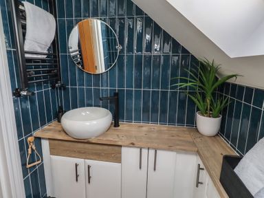 A bathroom with a sink and a mirror at Craster House in Seahouses