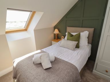 A bedroom with a single bed and window at Craster House in Seahouses