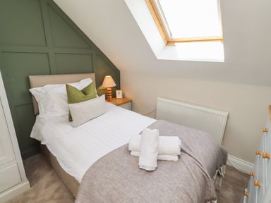 A bedroom with a bed and lamp at Craster House in Seahouses