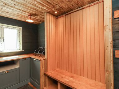 A mudroom with a bench and cabinet at Craster House Seahouses