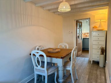 A dining room with a table and chairs at Rhianfa in Newborough
