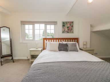 A bedroom with a bed, nightstands and a mirror at Cumbria house