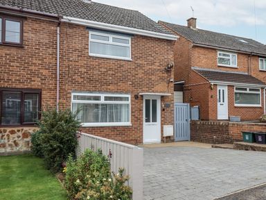 A brick house with a driveway and garden at Milana in Tiverton