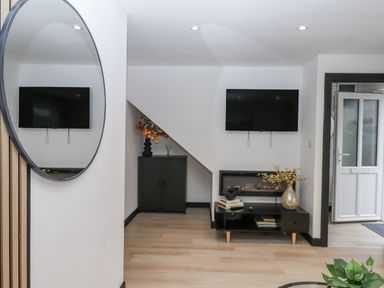 A living room with a television and furniture at Milana in Tiverton