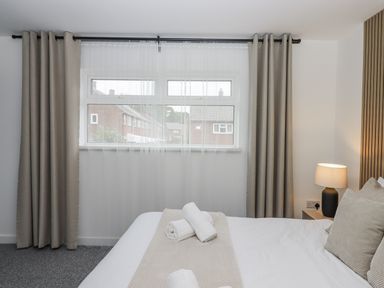 A bedroom with a window and bedding at Milana in Tiverton