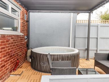An outdoor area with a hot tub and furniture at Milana in Tiverton