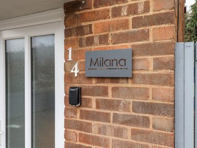 An entrance with a sign and a door at Milana in Tiverton