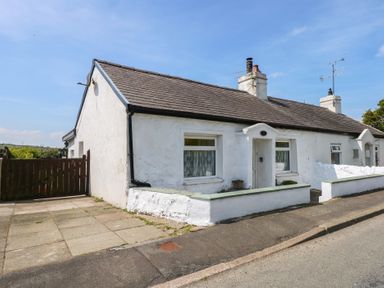 A white single-story house with a tiled roof and small front garden at Cobweb Cottage in Waunfawr