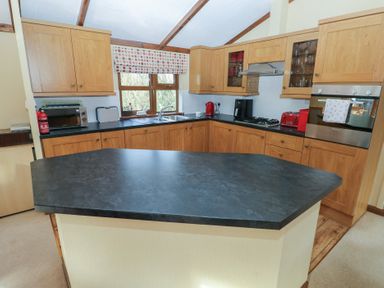A kitchen with cabinets and appliances at Riverside Lodge 3