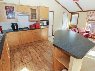 A kitchen with cabinets, stove, and fridge at Riverside Lodge 3