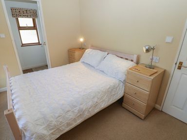 A bedroom with a bed and nightstand at Riverside Lodge 3