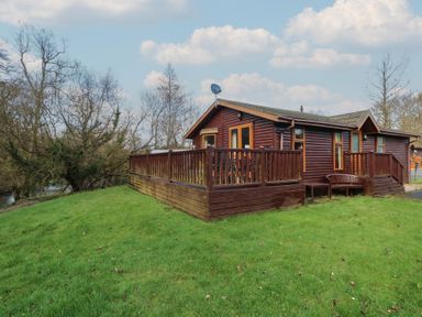 A lodge with decking and satellite dish at Riverside Lodge 3 