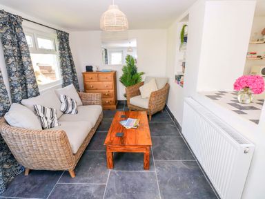 A living room with a sofa and armchair at Coach House Cottage