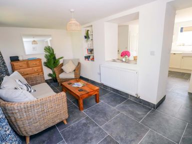 A living room with a sofa and coffee table at Coach House Cottage