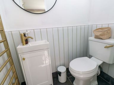 A bathroom with a sink and toilet at Coach House Cottage