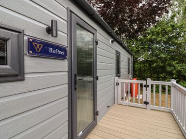 An entrance with door and sign at The Pines 2 Bedrooms in Delamere