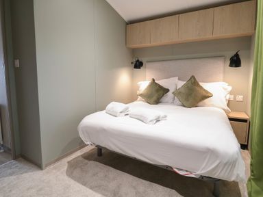A bedroom with a bed and bedside table at The Pines 2 Bedrooms in Delamere