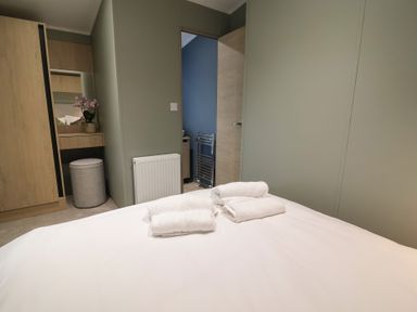A bedroom with a bed and towels at The Pines 2 Bedrooms Delamere